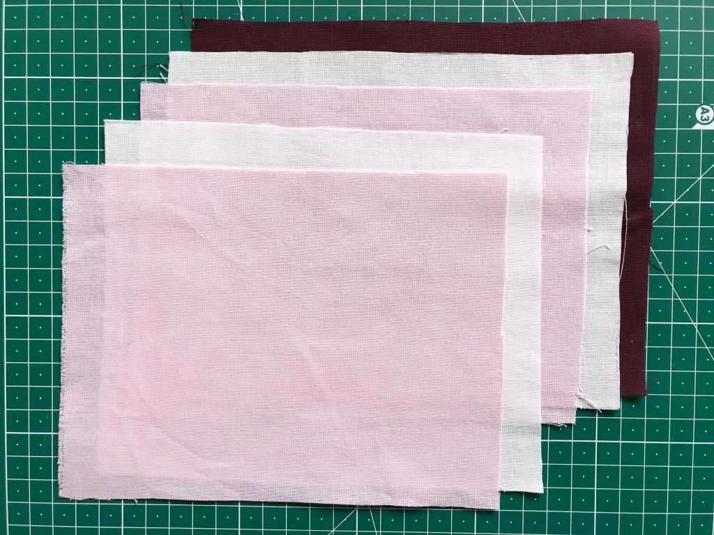 Stack of fabric rectangles prepared for faux chenille heart applique.