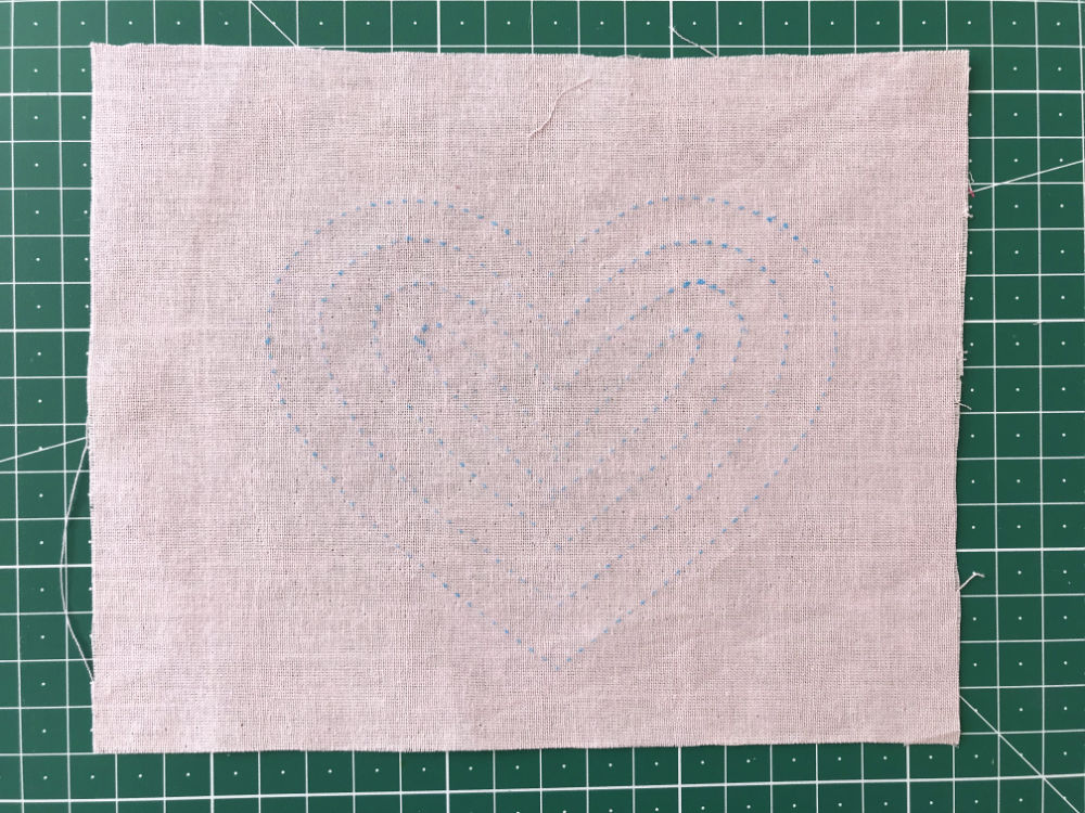 Heart template transferred to pink cotton fabric using a dressmakers tracing paper and tracing wheel.