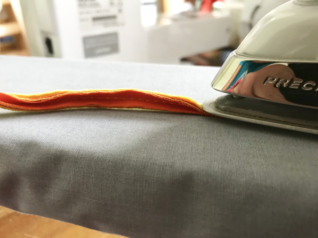 Ironing a stripe of stacked fabric.