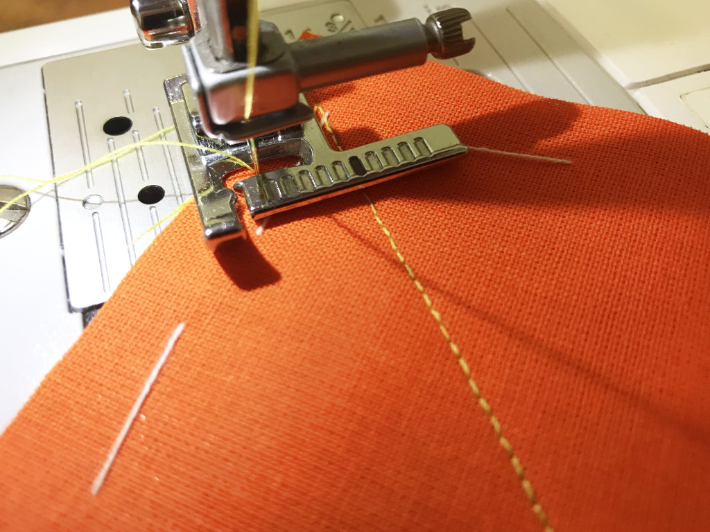 Sewing parallel lines using presser foot with a ruler.