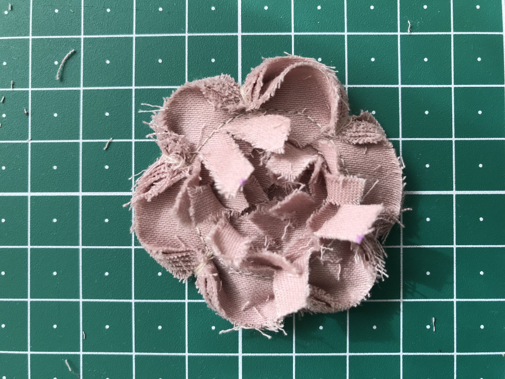 Faux-chenille style flower before cutting off excess stripes of fabric.