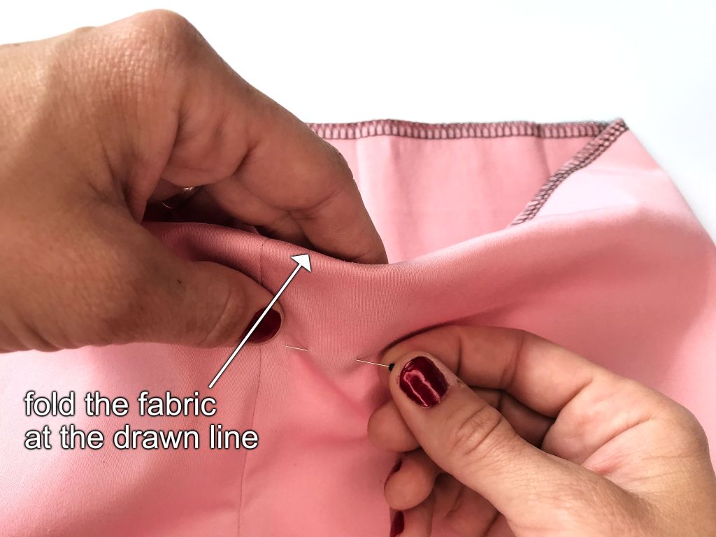 Folding and pinning fabric at the drawn line.