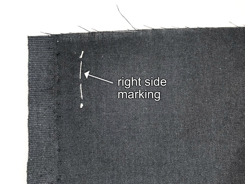 Marking the right side of a fabric along the selvage line with basting thread.