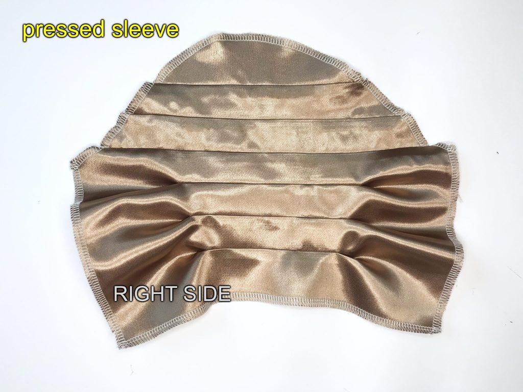 Pressed beige set-in satin sleeve with tucks on the wrong side.