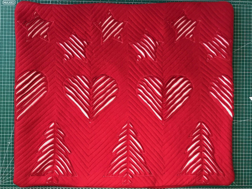 Slashed templates on a DIY faux chenille Christmas pillowcase.