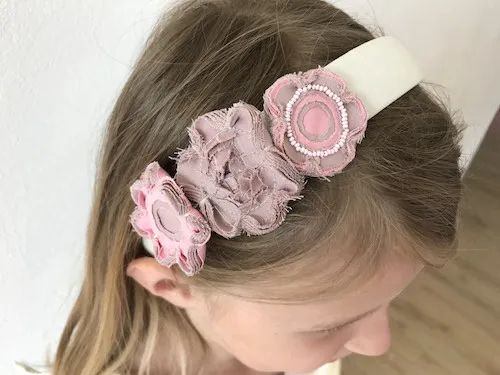 Headband with flower applique made by the faux chenille fabric manipulation technique.