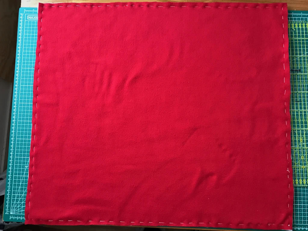 White and red fleece fabric basted together.