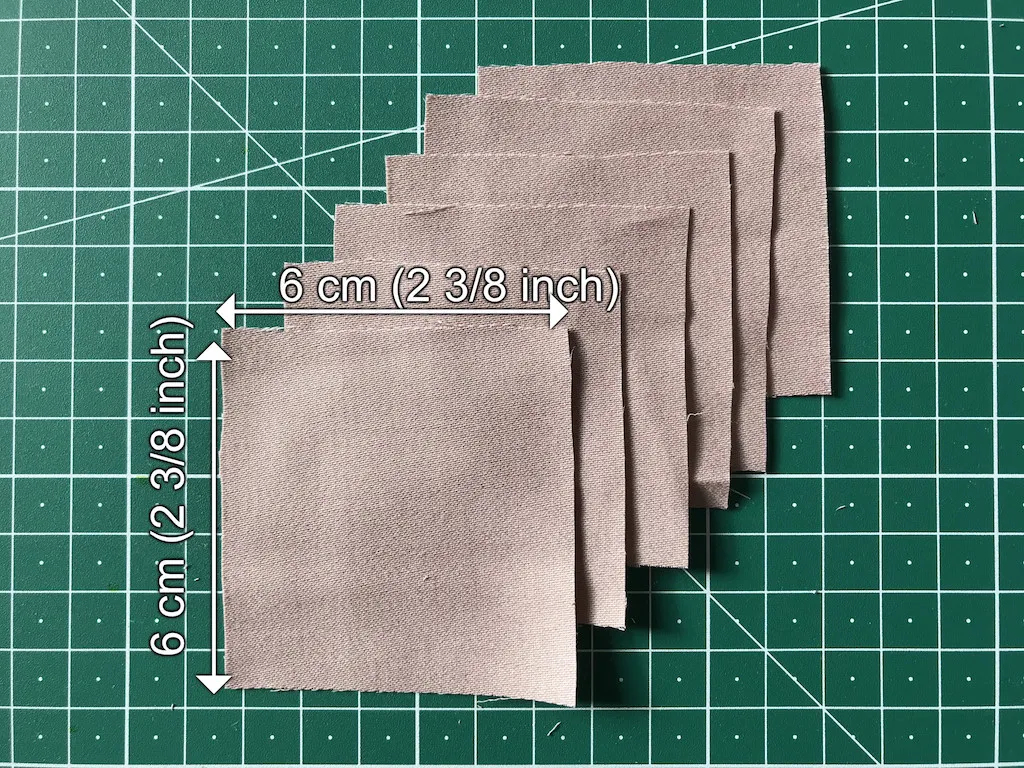Small squares of pink stretch fabric prepared for a DIY project.