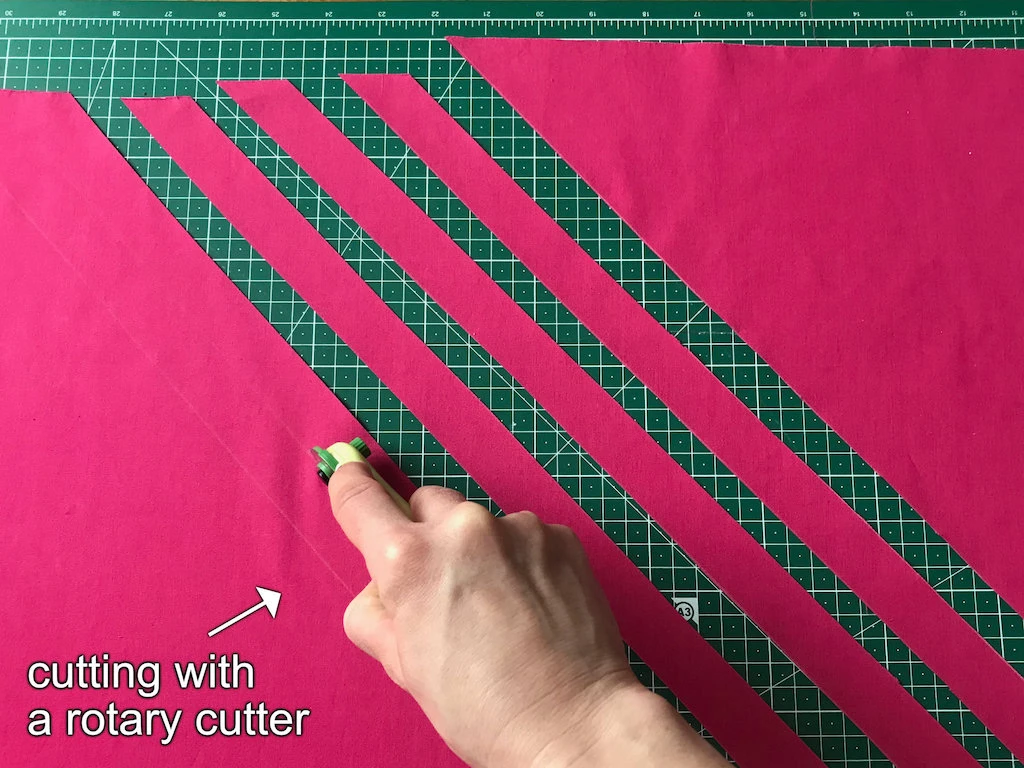 Cutting the fabric on the bias along pre-dawn lines with a rotary cutter.