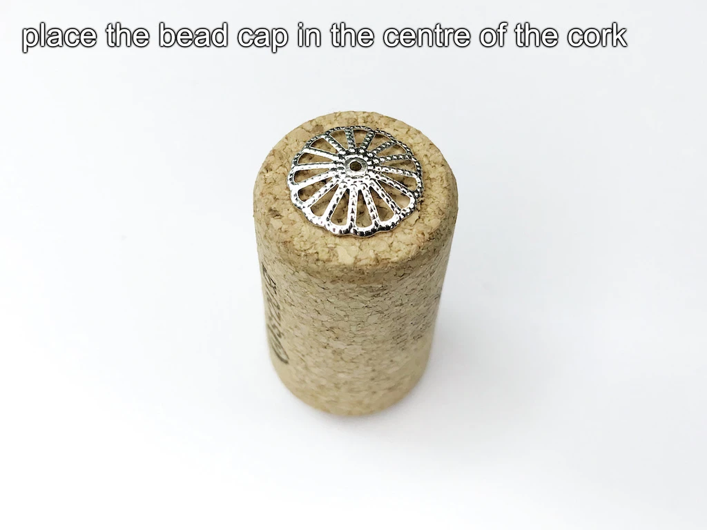 Bead cap placed in the middle of a straight bottle cork.