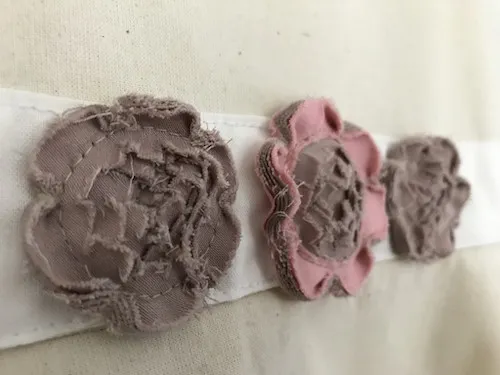 Waistband with small flower appliques made by the faux chenille fabric manipulation technique.