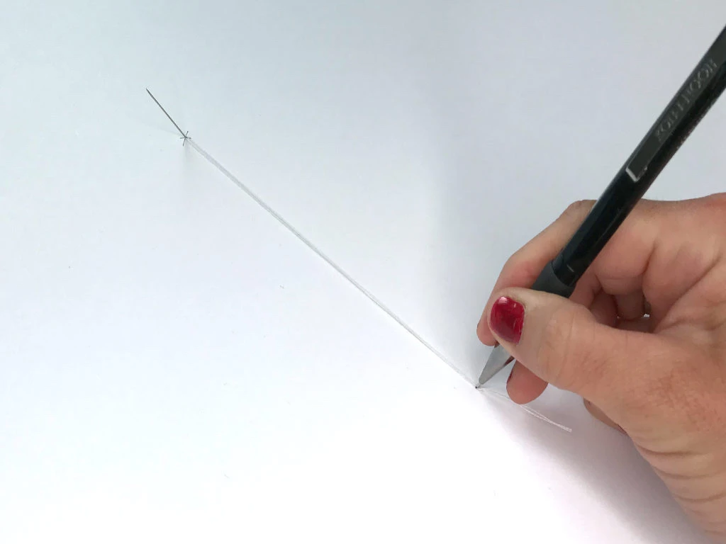 Inserting a pencil tip into a looped string.