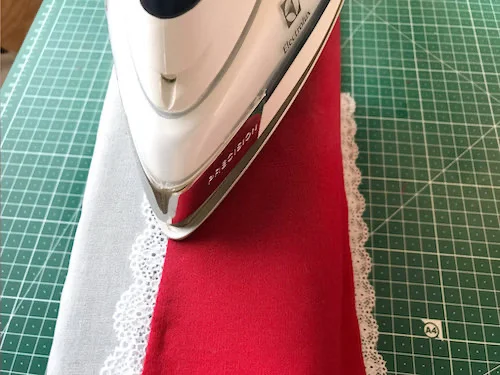 Pressing the sewn and folded lace trim.