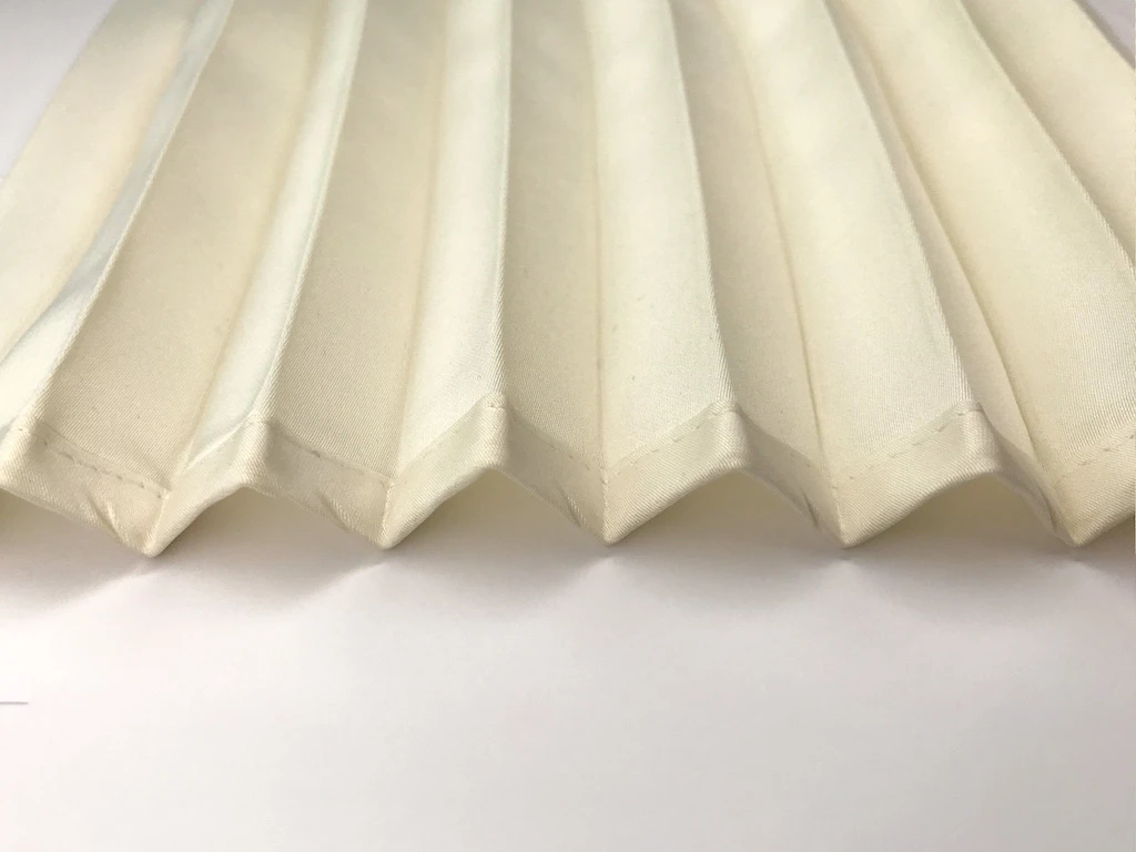 Bias binding tape applied to pleated satin fabric.