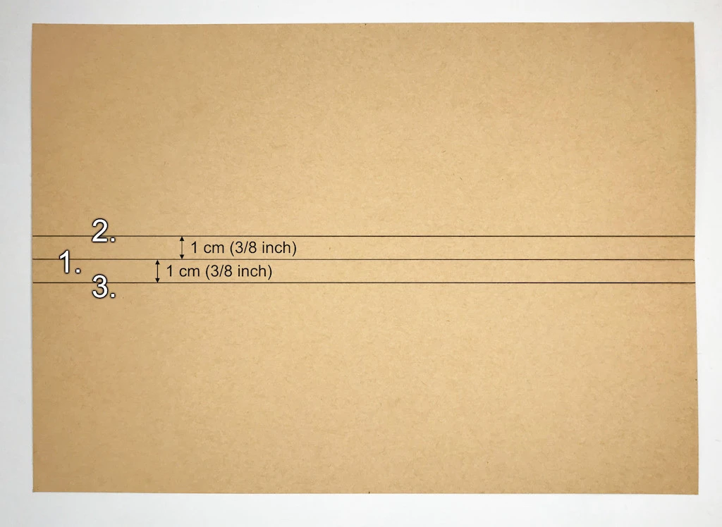 Drawing three horizontal parallel lines on kraft paper.