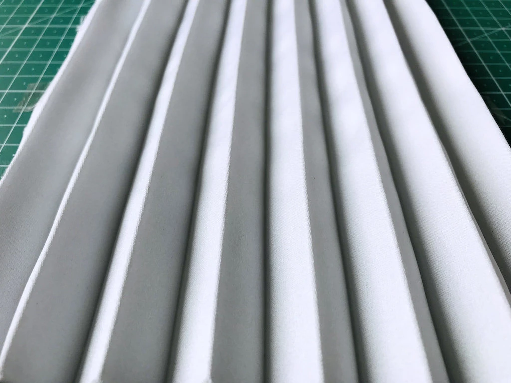 Hand pleated duchess satin fabric after being wrinkled and washed.