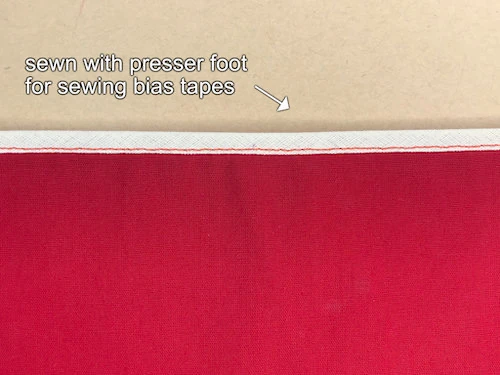 Tape sewn to hem using a bias binding tape and contrasting thread.