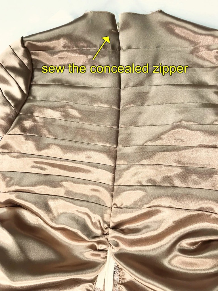 Concealed zipper sewn to the bodice back of the beige dress.
