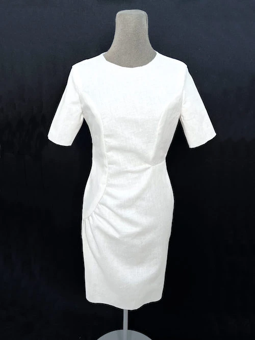 Asymmetric dress made of white cotton fabric.