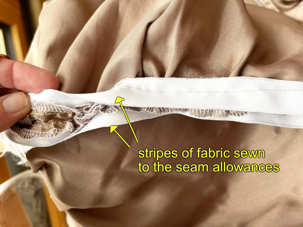 Stripes of fabric sewn to the seam allowances holdthe gathered fabric.