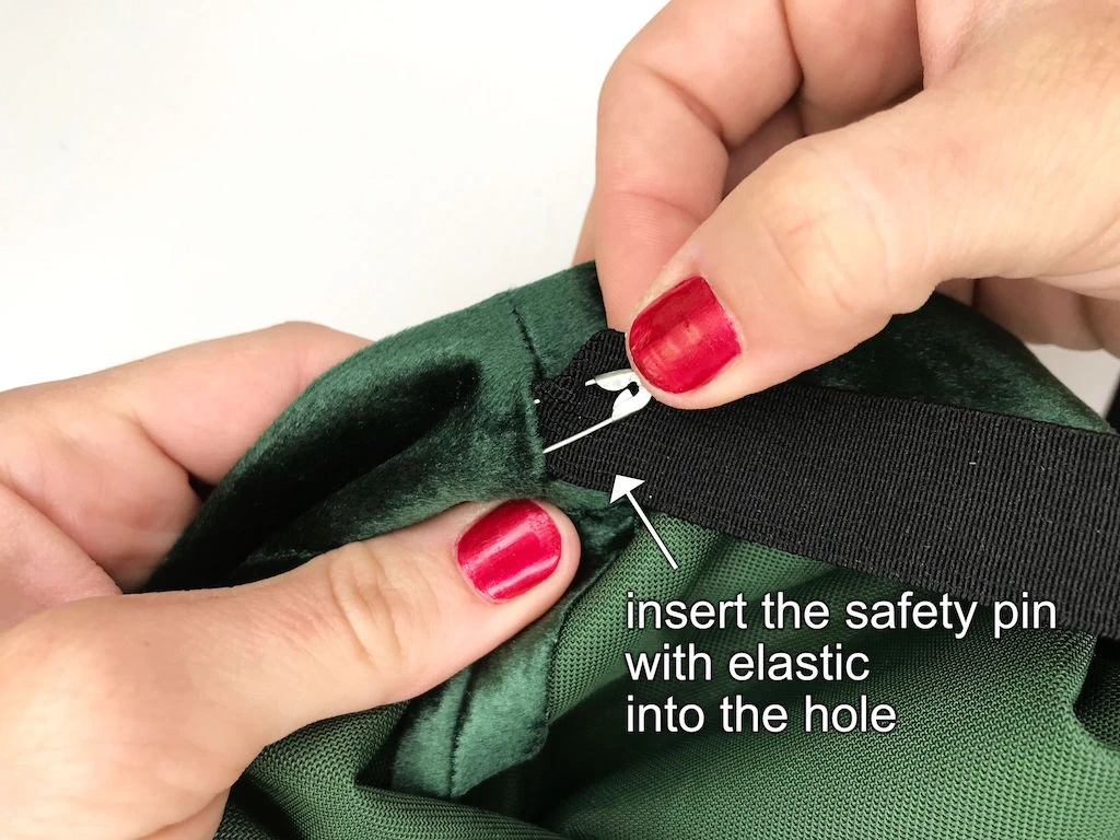 Inserting a safety pin with an attached elastic band into a waistband casing.
