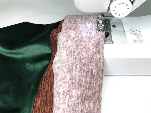 Sewing pink fabric to brown fabric on a sewing machine.