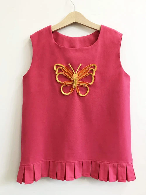 Pink tunic with pleated hem.