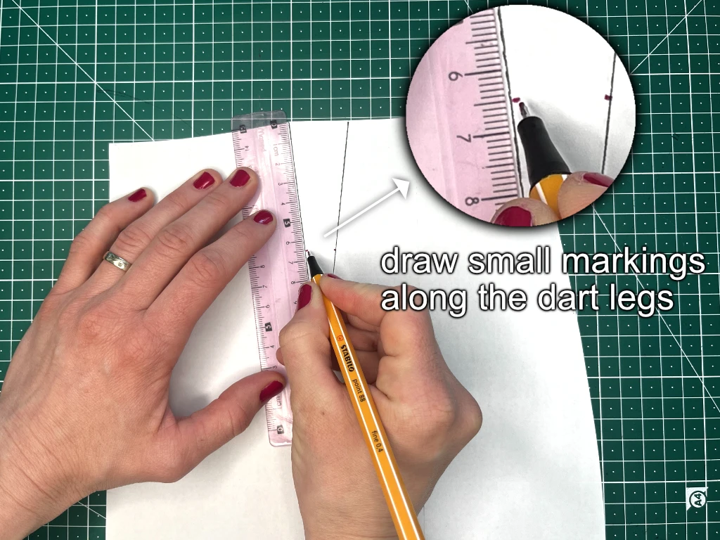 Marking the centre of a dart leg on a sewing pattern.