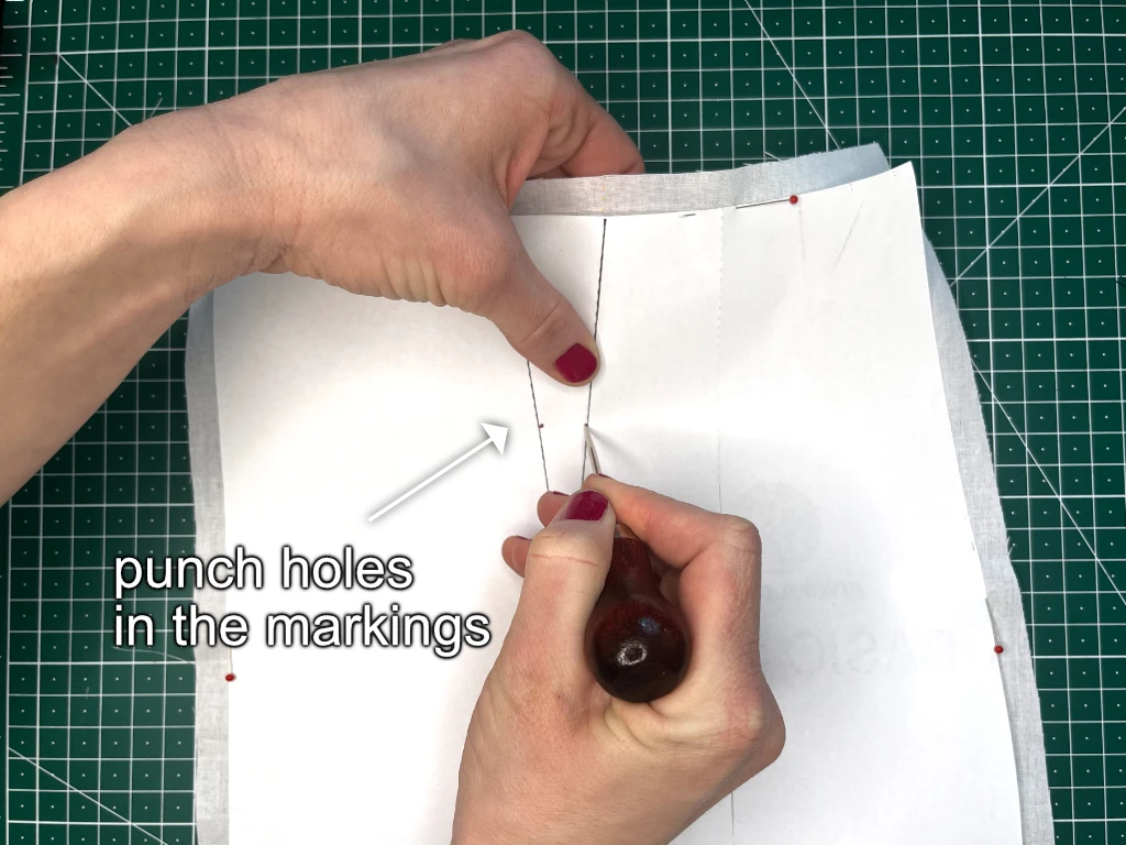 Transferring a darts in a sewing patter by punching holes into the fabric.